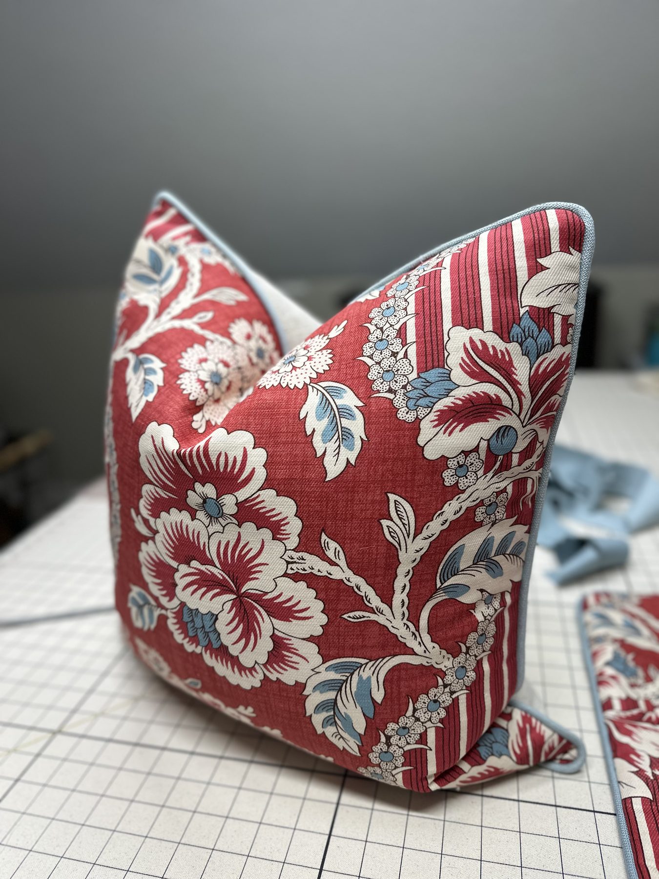 Red floral pillow with pale blue welt